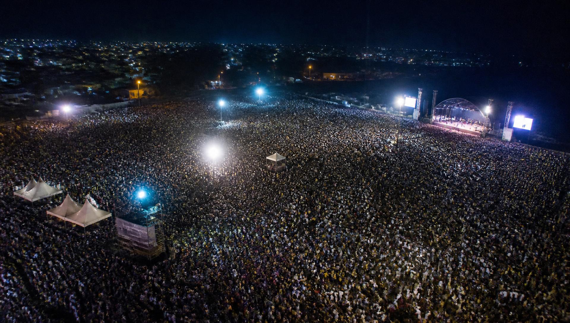 An aerial view of a vast night-time Gospel crusade crowd in Africa